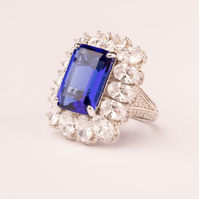 Emerald cut sapphire and pavé stone ring
