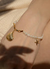 Bracelets en perles d'or, breloques coquillage et étoile de mer
