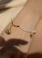 Design de pulseiras de pérolas de ouro e pingentes de estrela do mar
