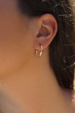 Boucles d'oreilles créoles en argent avec silhouette intérieure en zircone blanche